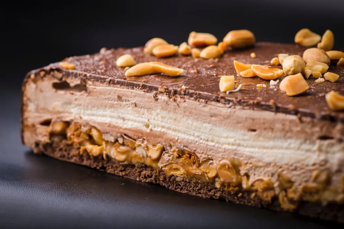 Close up of a slice of cake with chocolate cream and nuts